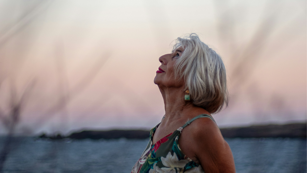 Mujer disfrutando de la naturaleza como símbolo de equilibrio y bienestar frente al estrés oxidativo y la salud auditiva