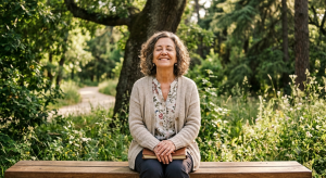 Adaptación de audífonos paso a paso: una mujer mayor sonriendo con los ojos cerrados mientras disfruta de los sonidos de la naturaleza en un parque.